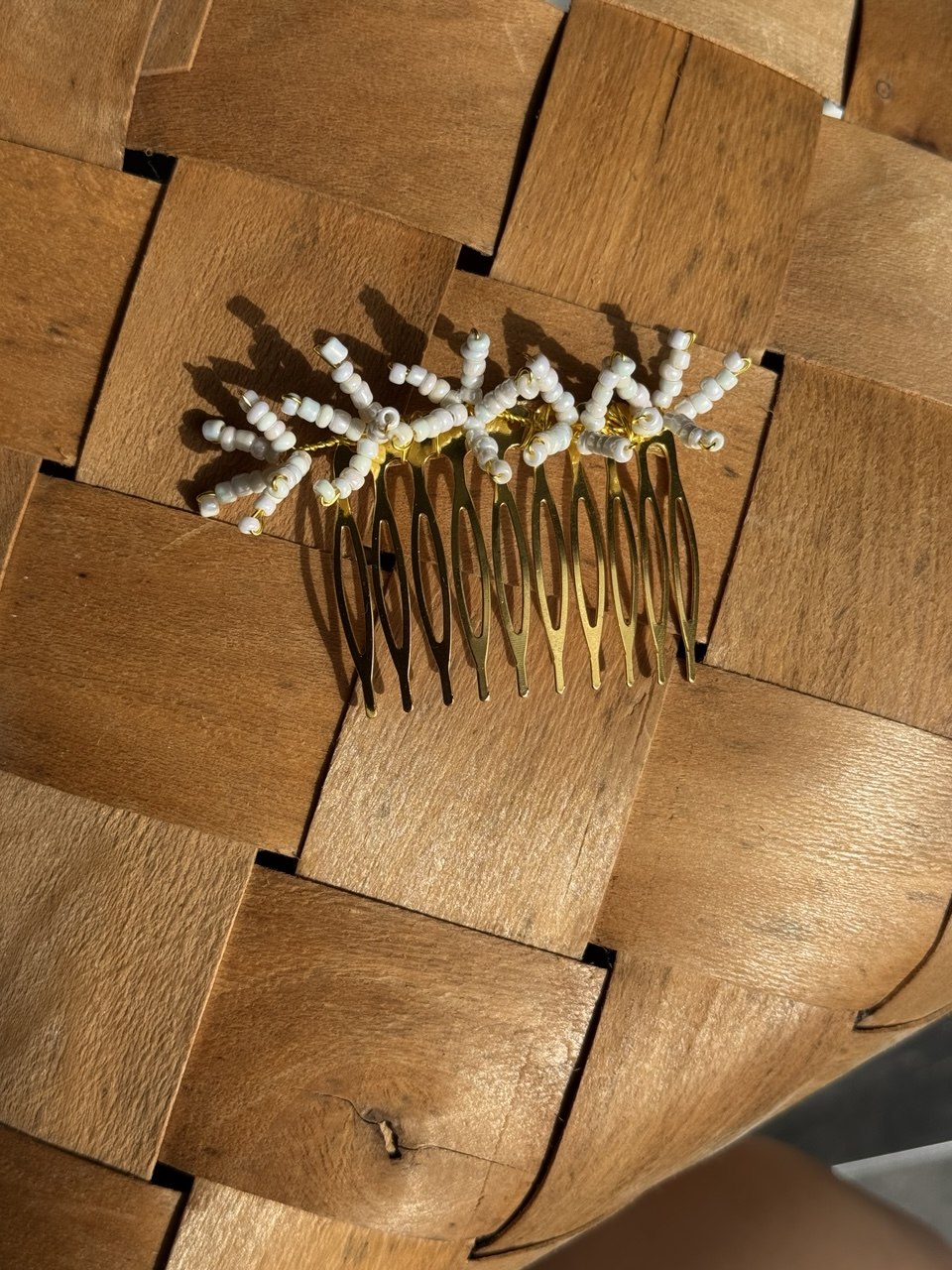 A gold hair comb with white pearl-like beads arranged in a floral or snowflake pattern order yours at Victoria's accesories