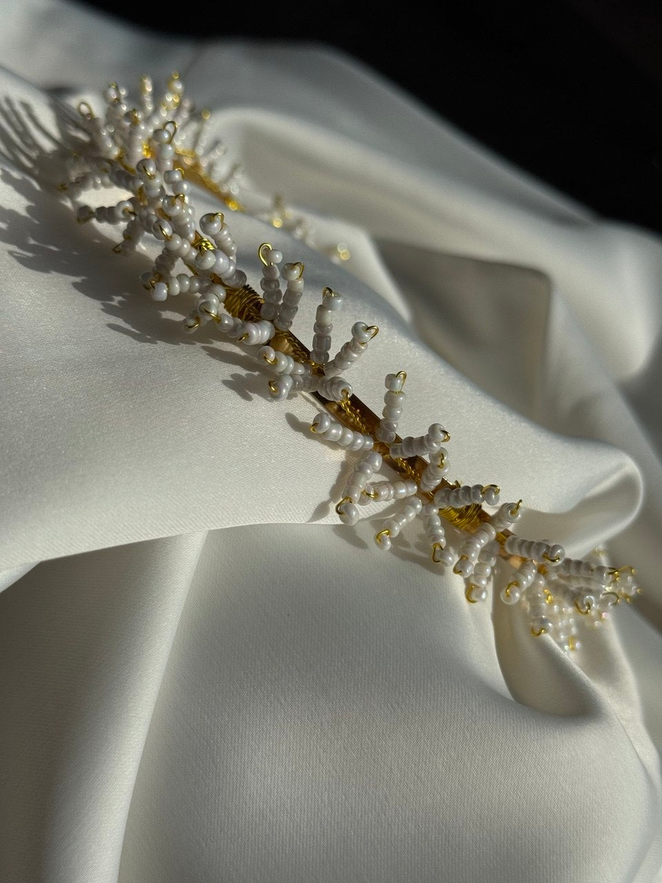 A delicate beaded hairpiece or tiara with white pearl-like beads and gold-toned accent - Victoria's Accessories